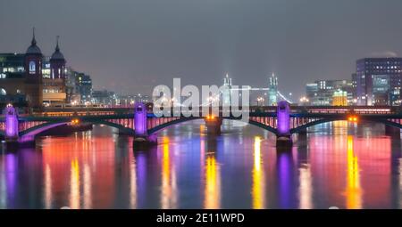 Vista panoramica sul famoso ponte storico di Londra, sul Tamigi e sulle Torri di Londra, illuminate di notte Foto Stock