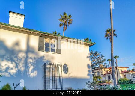 Casa con persiane e griglie sulla finestra contro il cielo blu A San Diego, California Foto Stock