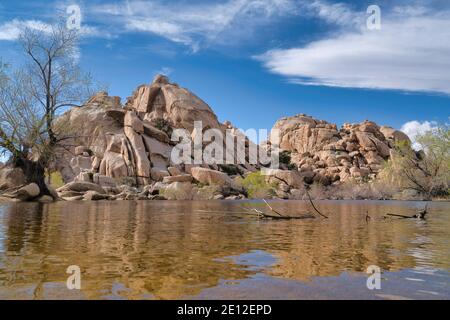 Grande bacino idrico di diga del corno al Joshua Tree National Park contro enormi rocce e cielo Foto Stock