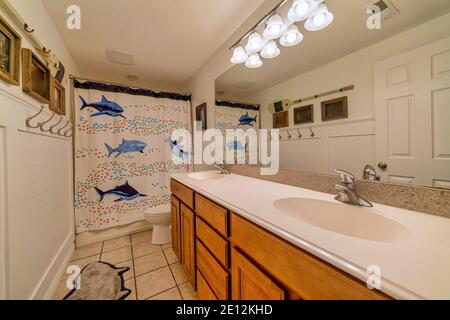 Interno del bagno con graziosa tenda doccia con la stampa dei delfini nelle vicinanze il wc Foto Stock