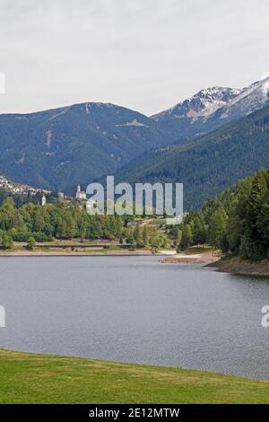 L'idilliaco piccolo Lago delle piazze di fronte al Villaggio dello stesso nome sull'altopiano di Pinehoe in Trentino Foto Stock