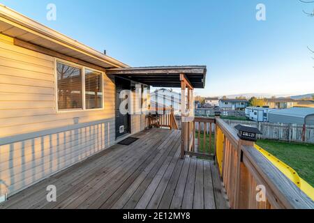 Ponte di legno con scivolo giallo e scale che si affacciano sulla erbosa cortile Foto Stock