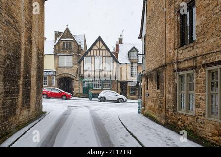 Witney Street guardando verso la strada alta nella neve. Burford, Cotswolds, Oxfordshire, Inghilterra Foto Stock