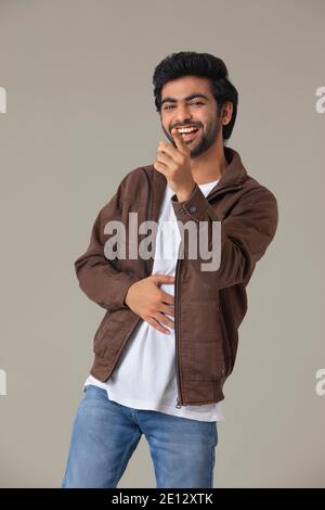 UN UOMO FELICE RIDENDO DURO E PUNTANDO STRAUGHT Foto Stock