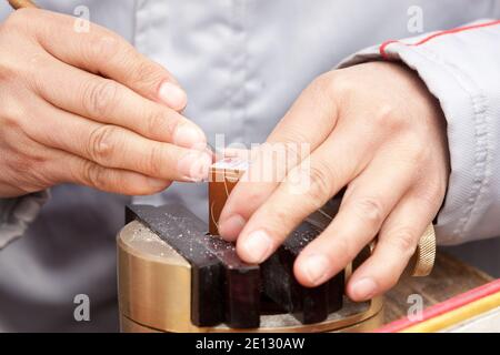 Pechino, Cina : le mani intagliano le cime tradizionali del nome della pietra (sigilli del nome o timbri del nome) al mercato antico di Panjiayuan. Foto Stock