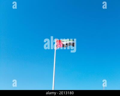 La bandiera degli Emirati Arabi Uniti sventolando contro il bel blu cielo in una giornata di sole Foto Stock