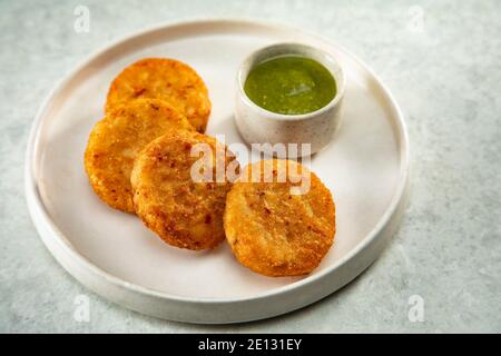 ALO TIKKIS FRITTO E PROFONDO SERVITO SU UN PIATTO CON CHUTNEY Foto Stock