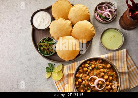 PURIS E CHOLE FRITTI SERVITI INSIEME A TAVOLA Foto Stock