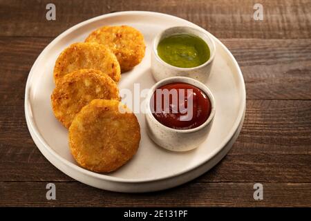 ALO TIKKIS FRITTO E PROFONDO SERVITO CON CHUTNEY E SALSA Foto Stock