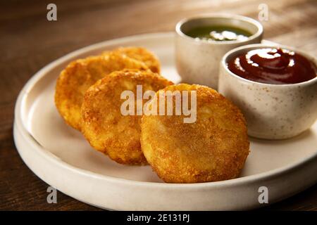 ALOO TIKKIS CROCCANTE SERVITO CALDO CON CHUTNEY E SALSA Foto Stock