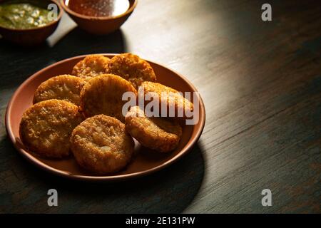 ALOO TIKKIS CROCCANTE SERVITO SU UN PIATTO E MANTENUTO SU TABELLA Foto Stock
