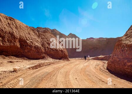 Due persone che camminano attraverso un canyon sabbioso nel deserto di puna, Argentina, Ande Foto Stock