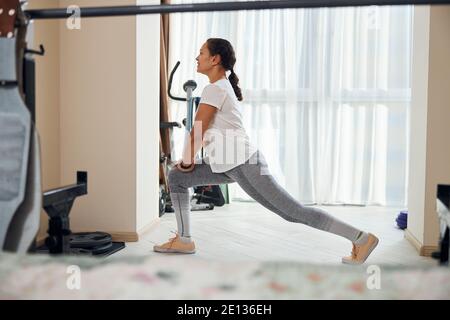 Gioiosa signora sportiva godendo il suo esercizio stretching Foto Stock
