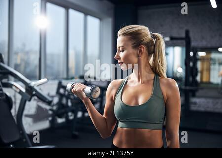 Bella donna pacifica durante un allenamento dumbbell Foto Stock