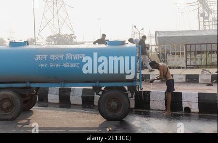 New Delhi, India, 2020 dicembre : i coltivatori di Sikh che prendono il bagno sull'autostrada nazionale nella mattina presto durante la protesta contro le nuove leggi di lontano in India. Foto Stock