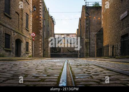 Cancelli della fabbrica di birra Guinness a Crane Street (ex Crane Lane) con vecchia pista ferroviaria. Dublino, Irlanda. Foto Stock