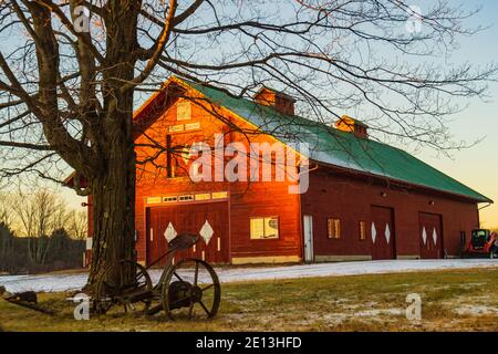 winter evening sun lighting up red barn Foto Stock