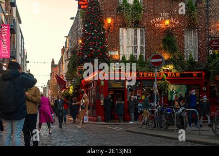 Persone felici che fanno selfie e fotografano contro il famoso Temple Bar Pub al tramonto. Dublino, Irlanda. Foto Stock