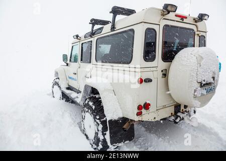 Un veicolo Land Rover Defender 4v4 4WD bianco in condizioni di lavoro gravose Neve in un'escursione turistica in Islanda Foto Stock