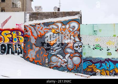 Colorato graffiti spray dipinto sulle pareti in un'area di scappamento del centro di Reykjavik, capitale dell'Islanda con una copertura di neve in inverno Foto Stock