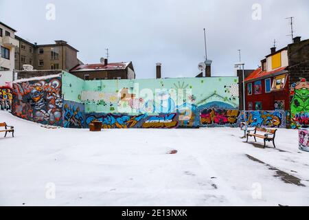 Colorato graffiti spray dipinto sulle pareti in un'area di scappamento del centro di Reykjavik, capitale dell'Islanda con una copertura di neve in inverno Foto Stock