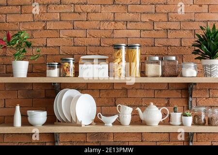 Set di utensili e vasetti con prodotti sui ripiani della cucina Foto Stock