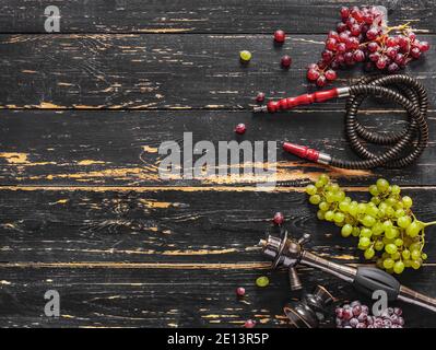 Parti di hookah e uva su sfondo ligneo Foto Stock