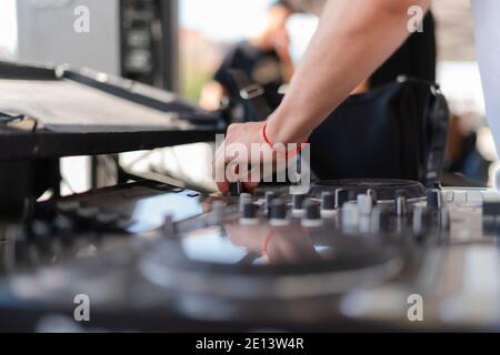 DJ che suona musica all'aperto. Persona che aziona il mixer al festival musicale. Primo piano di deejay mescolando alla festa Foto Stock
