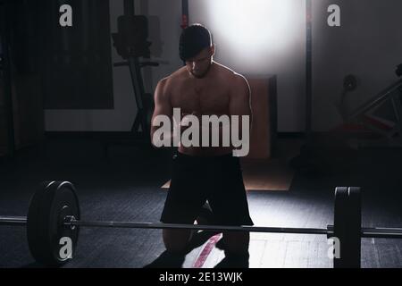 Bell'allenamento muscolare dell'uomo in palestra Foto Stock