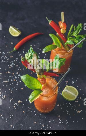 Due bicchieri di succo di pomodoro con vodka, sedano, spezie, sale e ghiaccio in porzioni bicchieri con spazio per la copia. Cocktail Bloody Mary. Bevanda alcolica e Ing Foto Stock