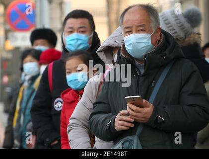 Pechino, Cina. 4 gennaio 2021. I cinesi indossano maschere di protezione durante l'attesa di un autobus a Pechino lunedì 4 gennaio 2021. La capitale cinese ha registrato nuovi casi di Covid-19 nell'ultima settimana, che hanno spinto le autorità locali a dichiarare uno "stato di emergenza". Foto di Stephen Shaver/UPI Credit: UPI/Alamy Live News Foto Stock