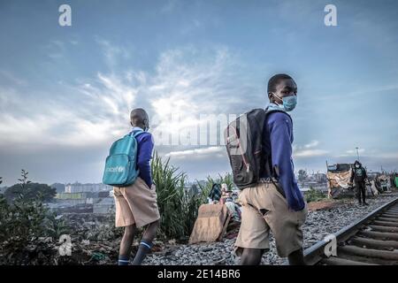 Nairobi, Kenya. 2 marzo 2019. I ragazzi che indossano maschere si dirigono a scuola la mattina presto dopo la riapertura delle scuole dopo nove mesi di assenza di scuola a causa della pandemia del coronavirus. Credit: Donwilson Odhiambo/SOPA Images/ZUMA Wire/Alamy Live News Foto Stock