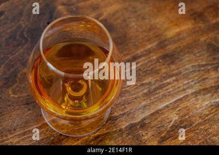 Brandy snifter bicchiere di alcol cognac bevanda su tavolo di legno, vista dall'alto, spazio copia Foto Stock