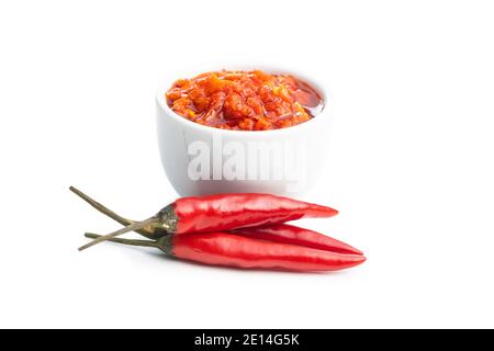 Pasta di peperoncino rosso caldo in ciotola e peperoncino isolato su sfondo bianco. Foto Stock