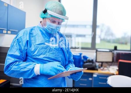 Ricercatore in laboratorio di biotecnologia con computer tablet che fa ricerca su internet Foto Stock