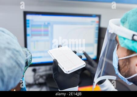 I ricercatori lavorano sull'esperimento per il vaccino Covid-19 nelle biotecnologie laboratorio Foto Stock