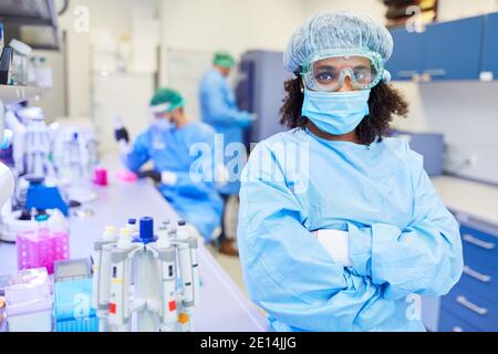 La donna africana lavora con il team del laboratorio per la ricerca Contro Covid-19 e coronavirus Foto Stock