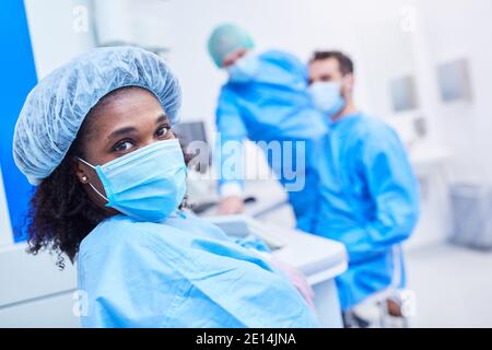 Donna africana come ricercatore nel laboratorio biotech con maschera facciale e rete per capelli Foto Stock