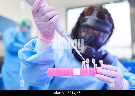 Il chimico riempie le fiale con il vaccino Covid-19 nel laboratorio di biotecnologia durante la pandemia del coronavirus Foto Stock