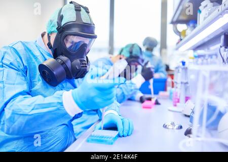 I ricercatori lavorano come team nel laboratorio su Covid-19 vaccinazione per la pandemia del coronavirus Foto Stock