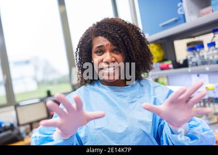 Donna africana come ricercatore nel laboratorio biotech durante la pandemia del coronavirus Foto Stock