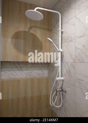 Luxury completamente rivestito di piastrelle con doccia testa pioggia e tenuto in mano la doccia rose Foto Stock