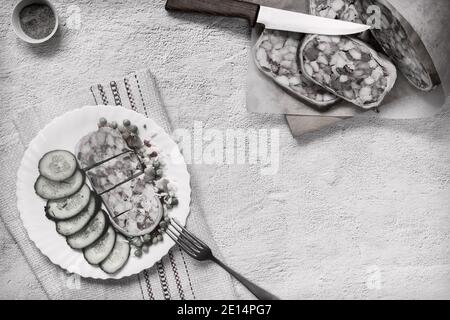 Sul tavolo su un piatto di delizioso antipasto di carne: Farcito con carne e pancetta di maiale stomaco, affettato, accanto a verdure e cetrioli freschi. Via superiore Foto Stock