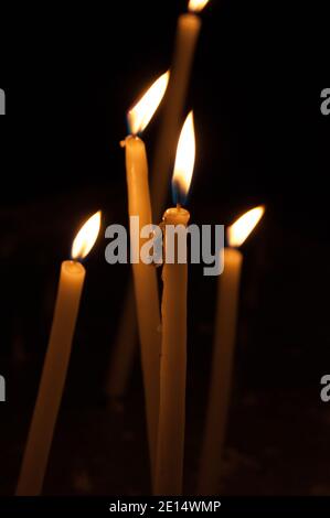 Cinque candele sottili su sfondo scuro. Cera gocciolante. Foto Stock