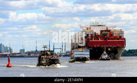 Moderno traghetto portuale, storico rompighiaccio a vapore e possente nave container con rimorchiatore sul fiume Elba ad Amburgo, Germania Foto Stock