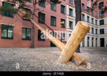 La posta di legno sostiene UN albero nella città Foto Stock
