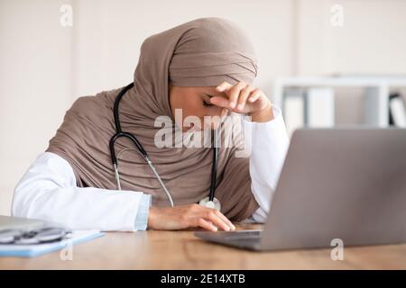 Donna musulmana esausta che lavora in clinica Foto Stock