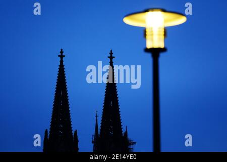 Colonia, Germania. 4 gennaio 2021. Una lanterna brilla la sera di fronte alla cattedrale. Credit: Liver Berg/dpa/Alamy Live News Foto Stock