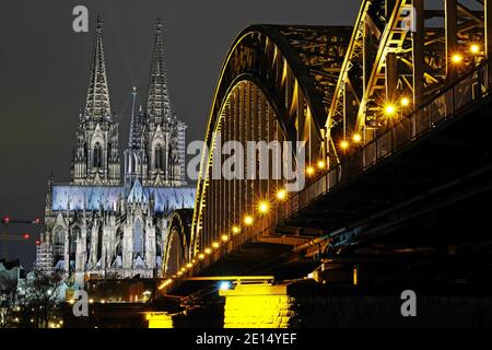 Colonia, Germania. 4 gennaio 2021. La cattedrale (l) è illuminata di sera accanto al ponte Hohenzollern. Credit: Liver Berg/dpa/Alamy Live News Foto Stock