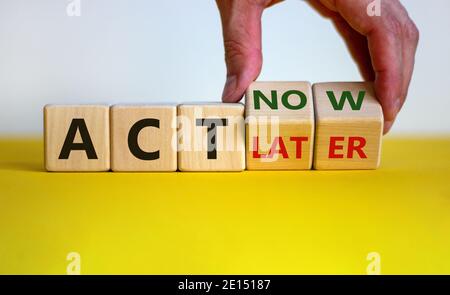 Agire ora, non più tardi simbolo. La mano maschio gira i cubetti di legno e cambia le parole 'ACT later' in 'ACT now'. Business e agire ora o concetto successivo. Bella y Foto Stock